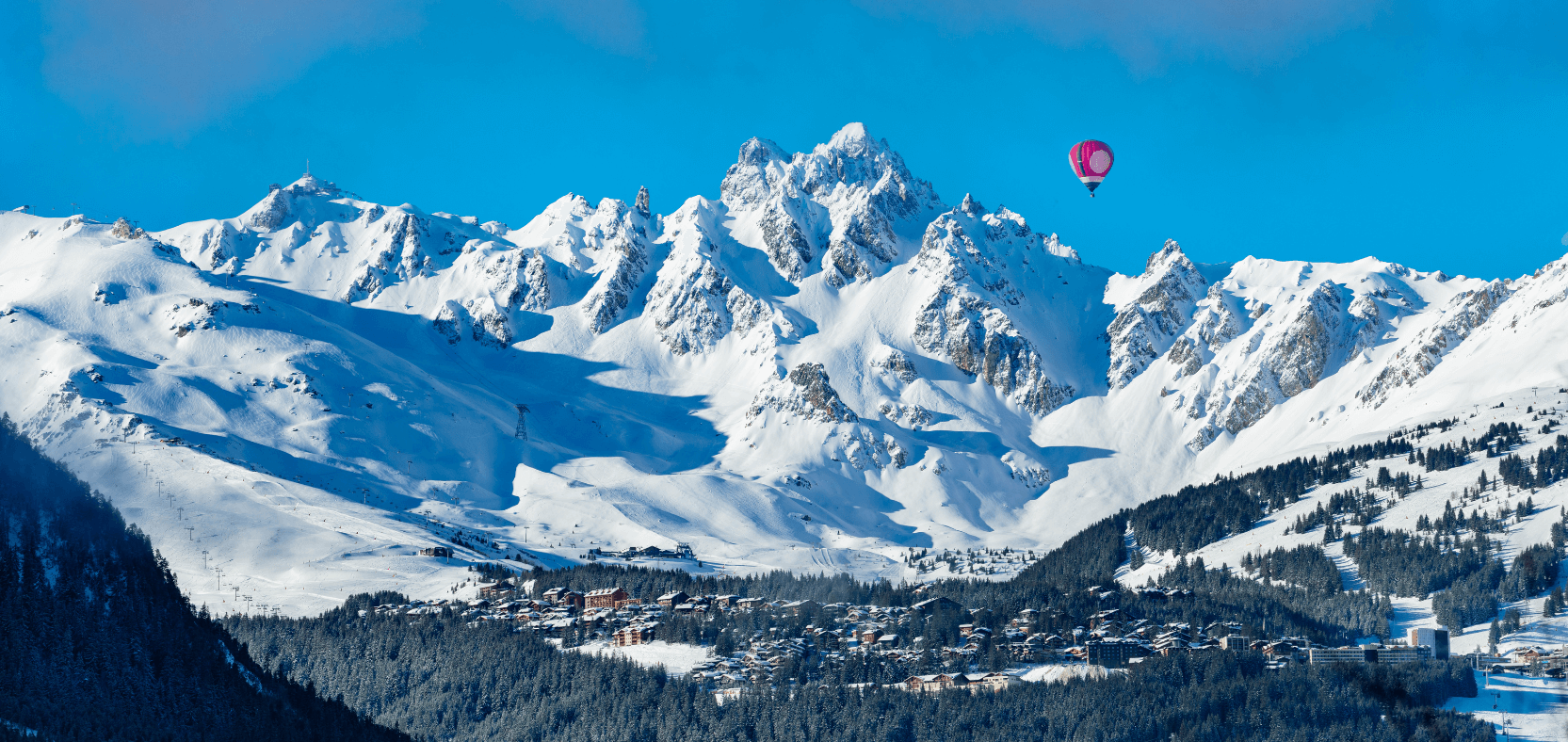 Beautiful view of Courchevel village with hot air balloon in the distance.