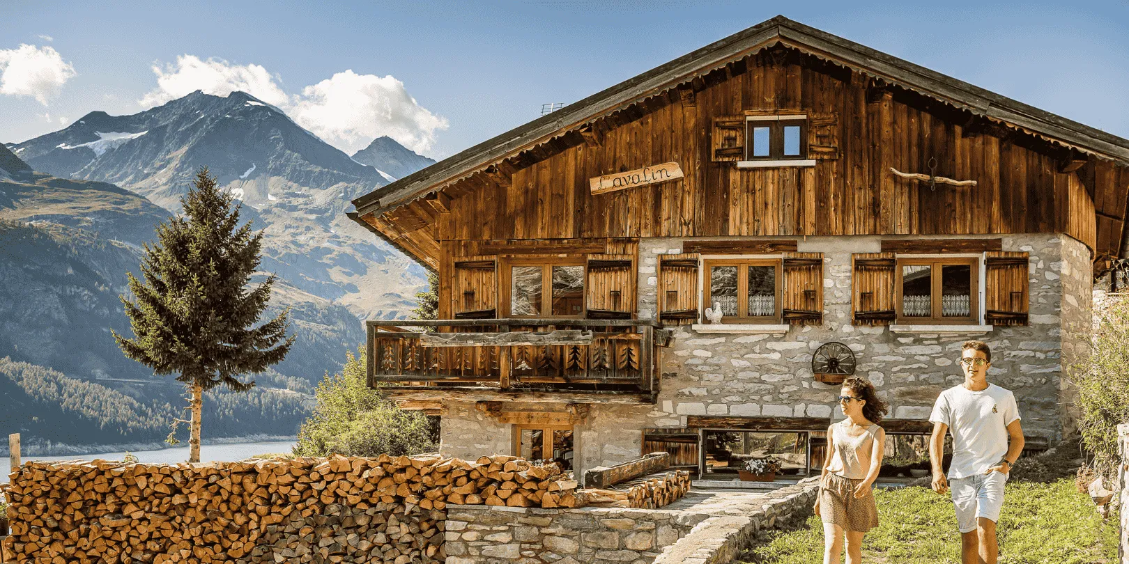Couple walking in front of Tignes Chalet in the summer